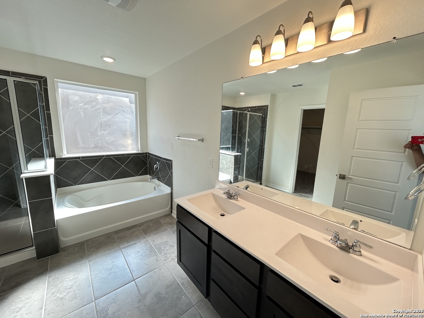 6608 Runaway Row Converse, TX 78109 - Photo 12 of 17 a bathroom with a tub double vanity sink and a mirror