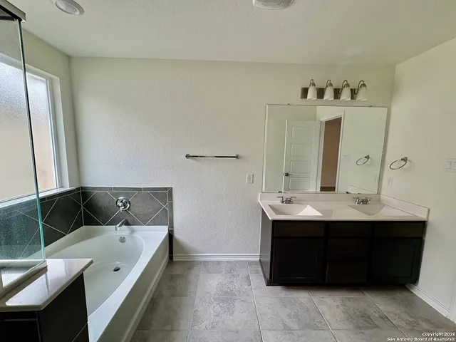 a bathroom with a bathtub sink and mirror