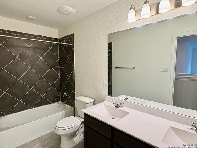a bathroom with a sink mirror vanity and toilet