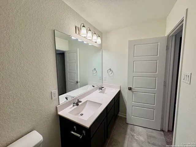 a bathroom with a sink a toilet and mirror
