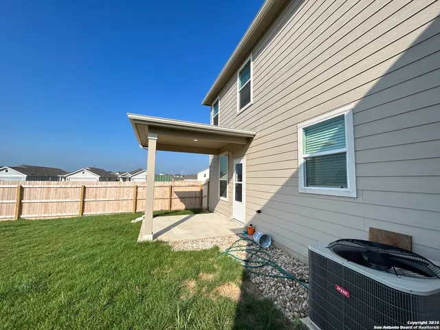 a view of backyard of house with green space