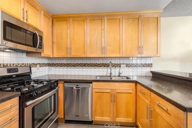 a kitchen with stainless steel appliances granite countertop a stove a sink and a microwave