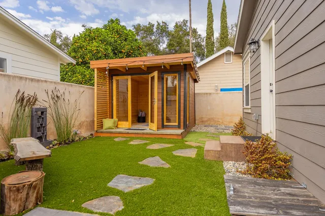 a view of a backyard with table and chairs and potted plants