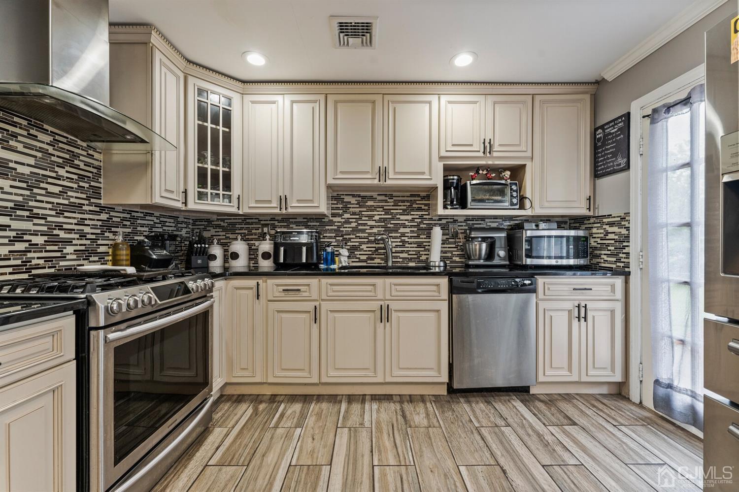 205 Midfield Road Colonia, NJ 07067 - Photo 9 of 26 a kitchen with stainless steel appliances granite countertop a stove a sink and a refrigerator