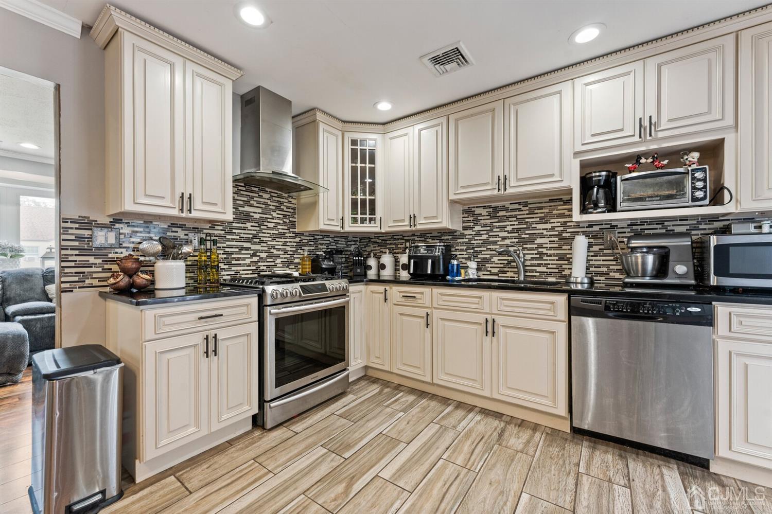 205 Midfield Road Colonia, NJ 07067 - Photo 10 of 26 a kitchen with stainless steel appliances granite countertop a stove a sink and white cabinets