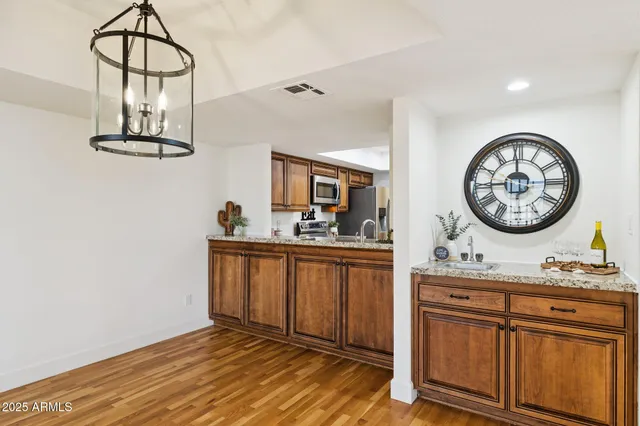 a view of a kitchen cabinets a sink and a stove with wooden floor