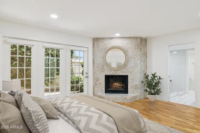 a bedroom with a bed a fireplace and a large window