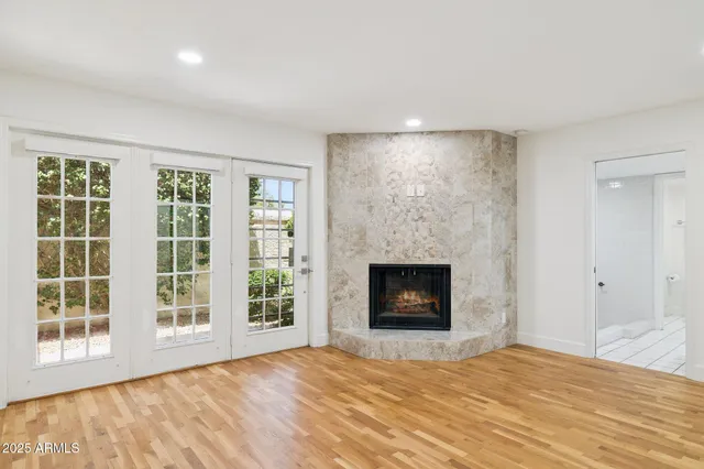 a view of an empty room with a window and fireplace