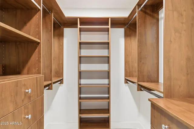a view of walk in closet with empty racks