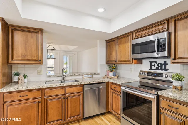 a kitchen with stainless steel appliances granite countertop a sink stove and microwave