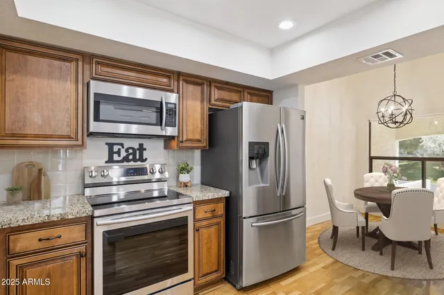 a kitchen with granite countertop a refrigerator stove and microwave