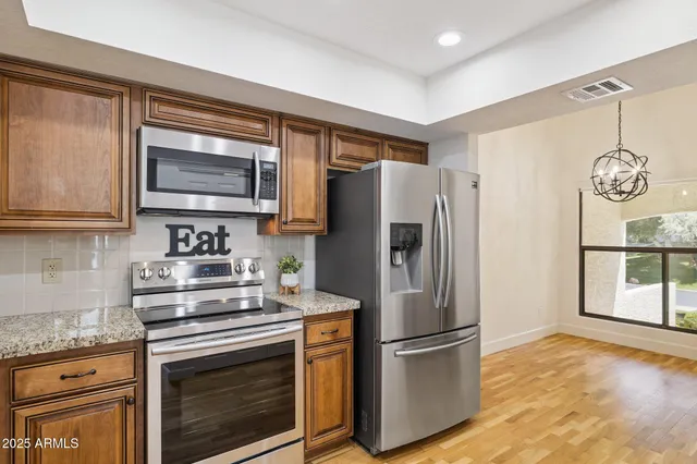 a kitchen with appliances a refrigerator and cabinets