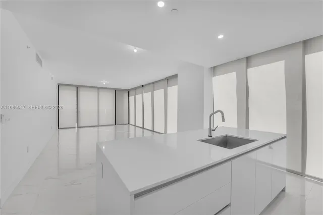 a kitchen with kitchen island a sink table and chairs