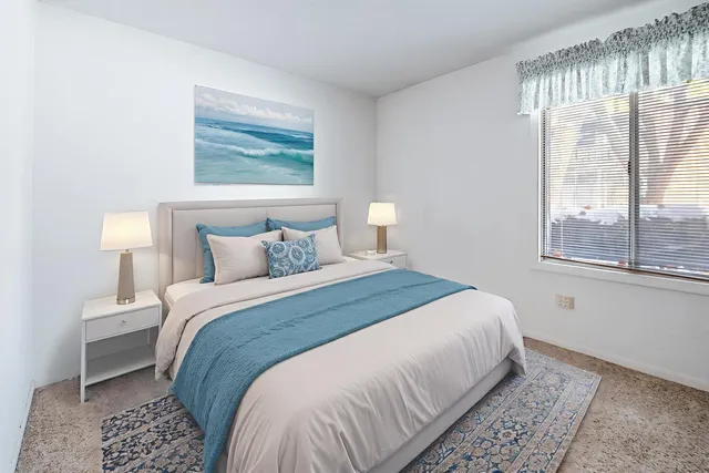 a bedroom with a bed and a window