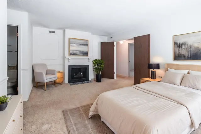 a bedroom with a bed and a fireplace