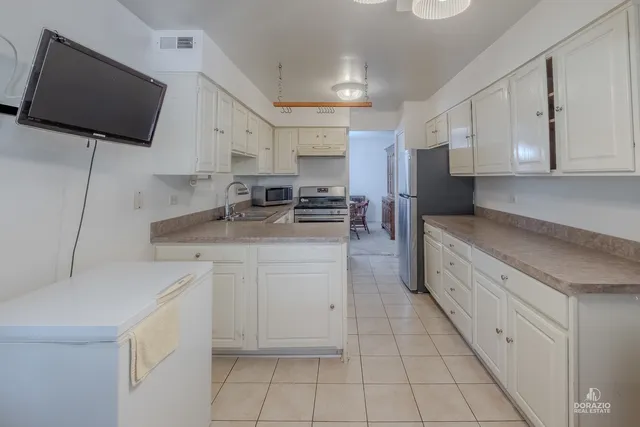 a kitchen with stainless steel appliances white cabinets a sink and a stove