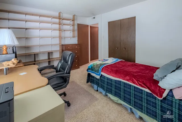a bedroom with a bed and a desk in it