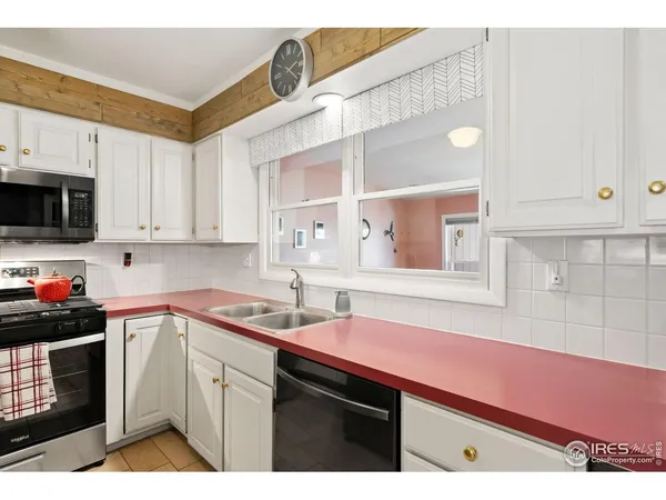 a kitchen with kitchen island a counter space a sink appliances and cabinets