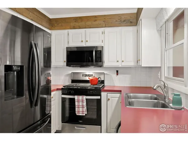 a kitchen with a sink cabinets and a window