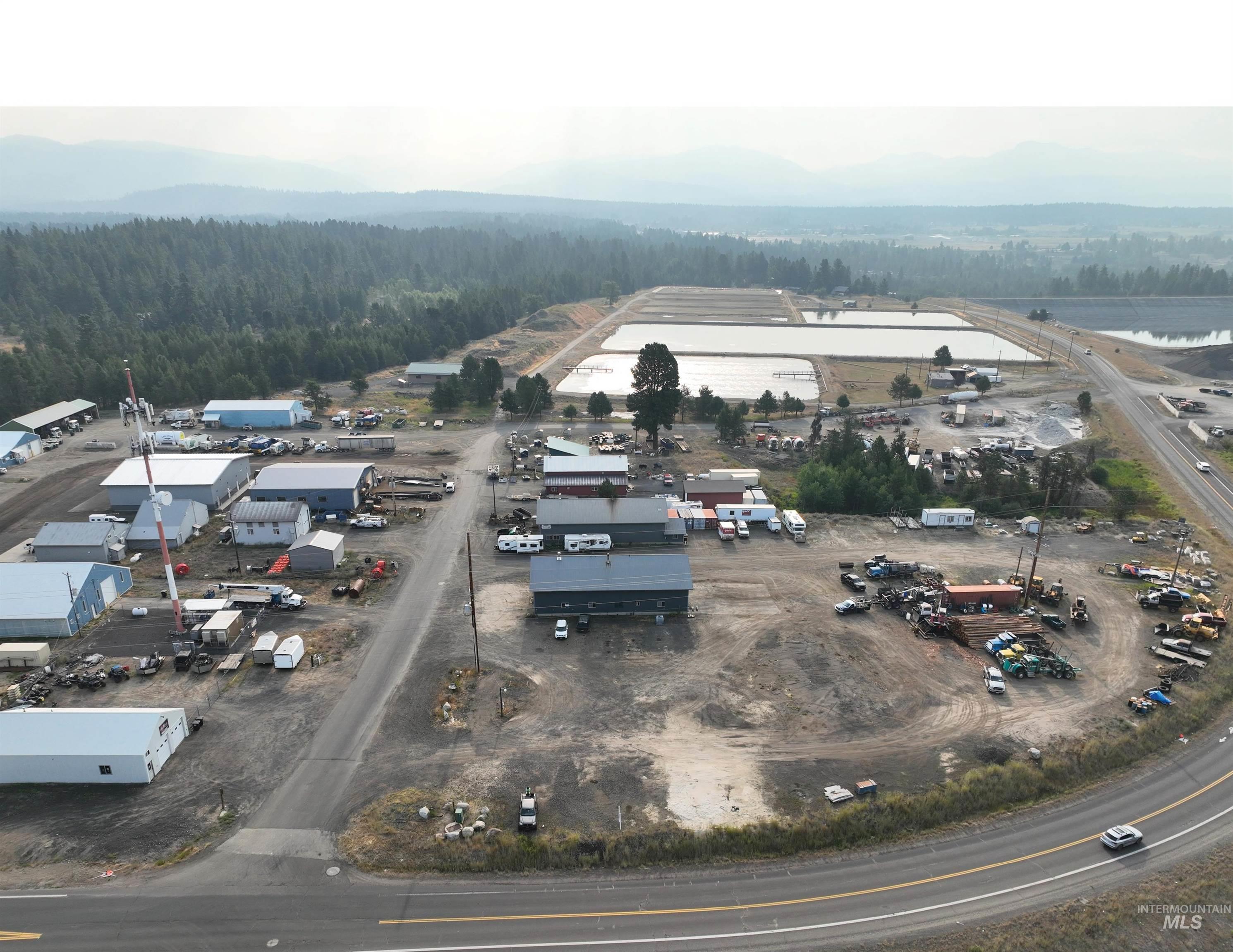 228 Industrial Loop McCall, ID 83638 - Photo 2 of 4 Drone / aerial view of a heavily wooded area and a mountain backdrop