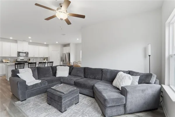 a living room with furniture and a view of kitchen