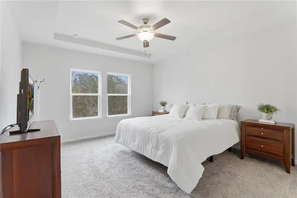 a spacious bedroom with a bed a large window and flat screen tv