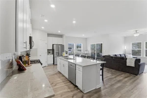 a large white kitchen with stainless steel appliances