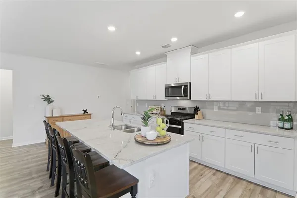 a kitchen with a sink white cabinets and appliances