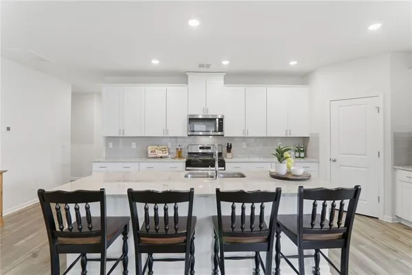 a kitchen with a dining table chairs and wooden floor