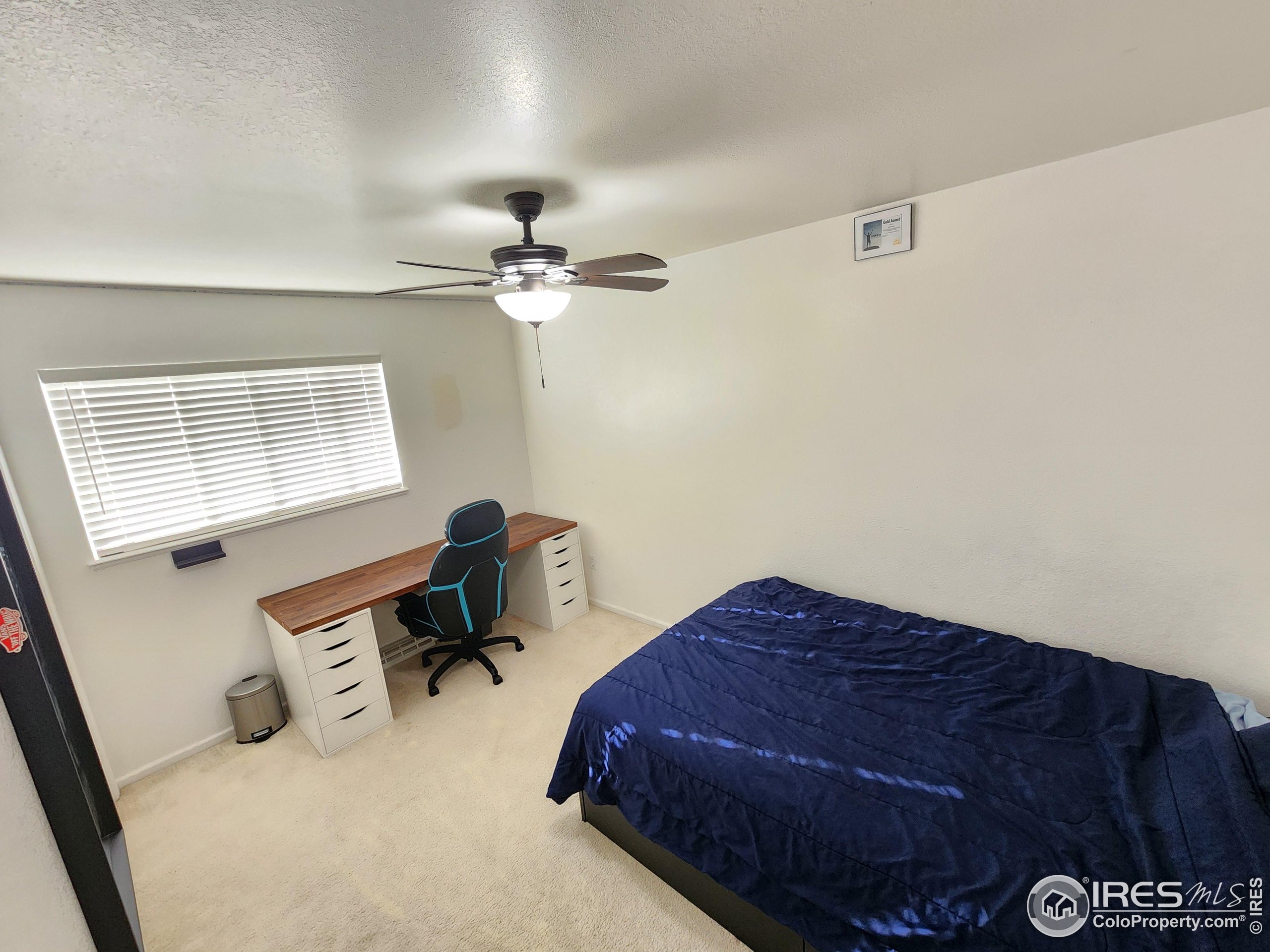 1324 Dawes Street Sterling, CO 80751 - Photo 12 of 39 a bedroom with a bed and a chandelier