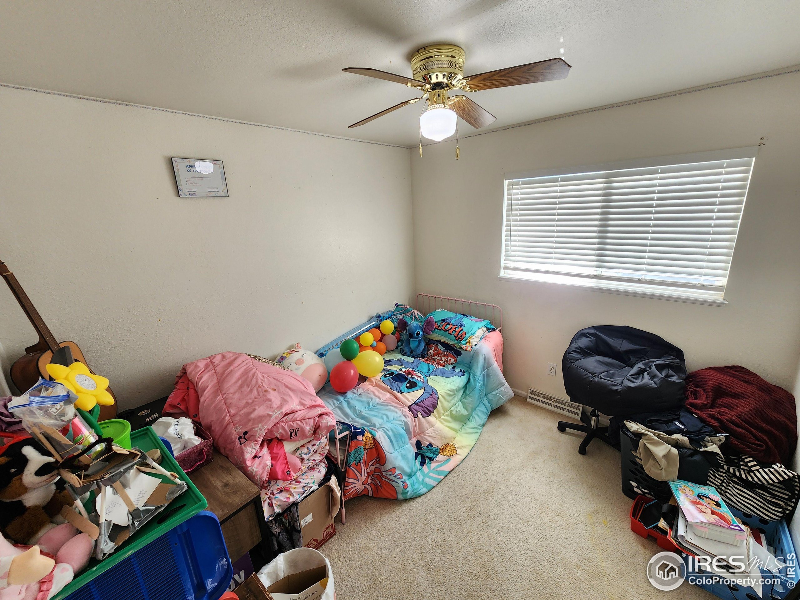 1324 Dawes Street Sterling, CO 80751 - Photo 18 of 39 a bedroom with a bed and a chandelier