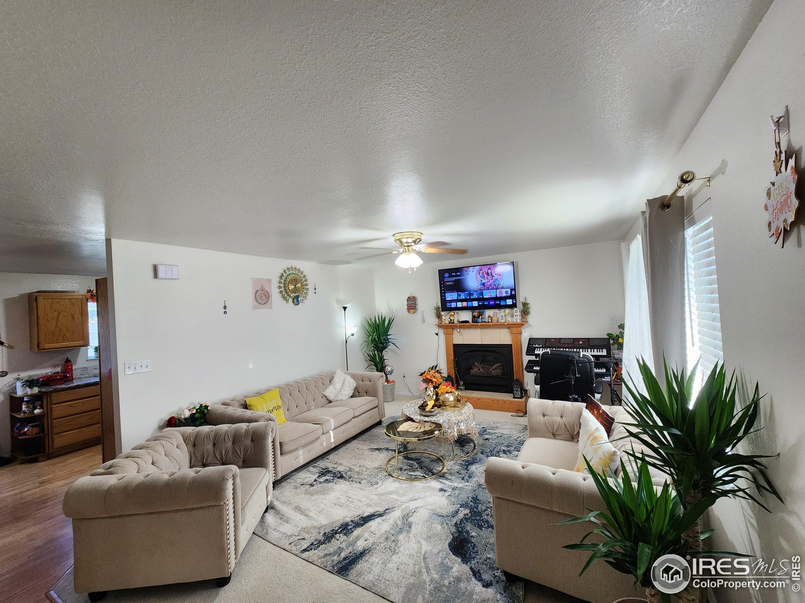 1324 Dawes Street Sterling, CO 80751 - Photo 2 of 39 a living room with furniture a potted plant and a flat screen tv