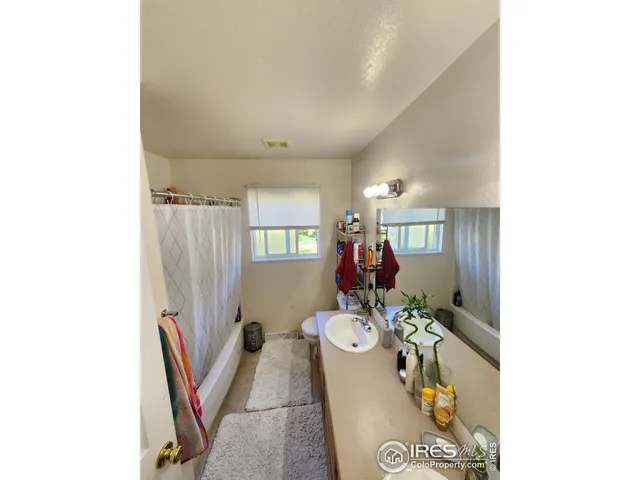 a living room with furniture a flat screen tv and a window