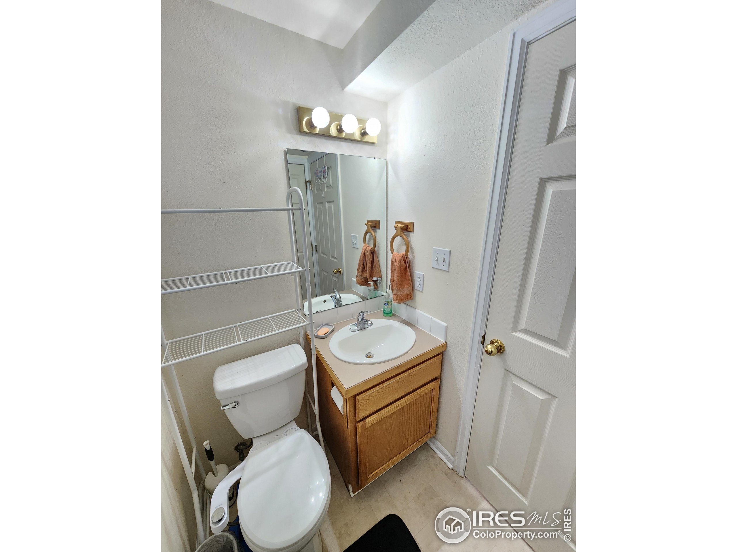 1324 Dawes Street Sterling, CO 80751 - Photo 27 of 39 a bathroom with a toilet a sink and mirror