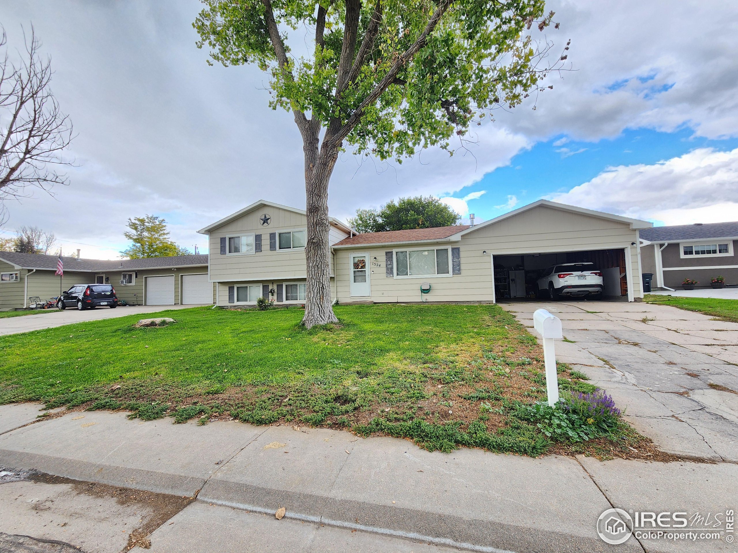 1324 Dawes Street Sterling, CO 80751 - Photo 34 of 39 a view of house with a yard and a large tree