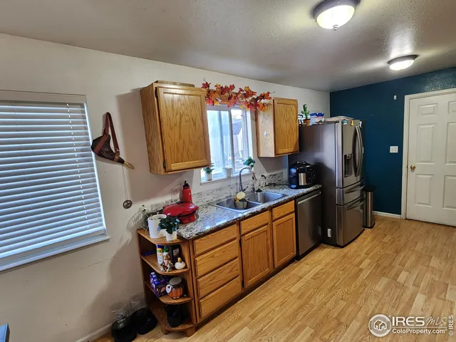 a kitchen with stainless steel appliances granite countertop a refrigerator stove and sink