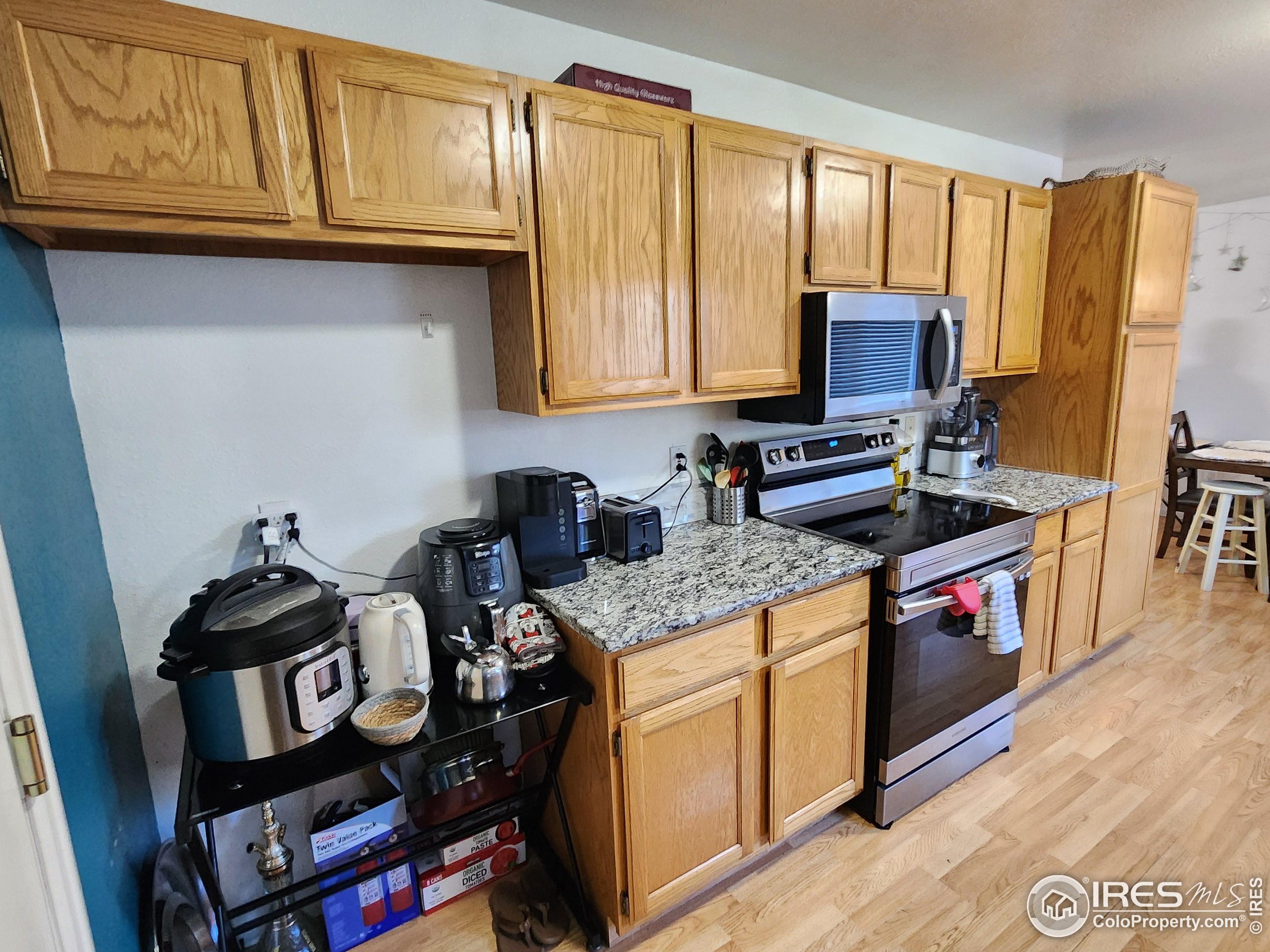 1324 Dawes Street Sterling, CO 80751 - Photo 7 of 39 a kitchen with granite countertop a stove top oven microwave and cabinets