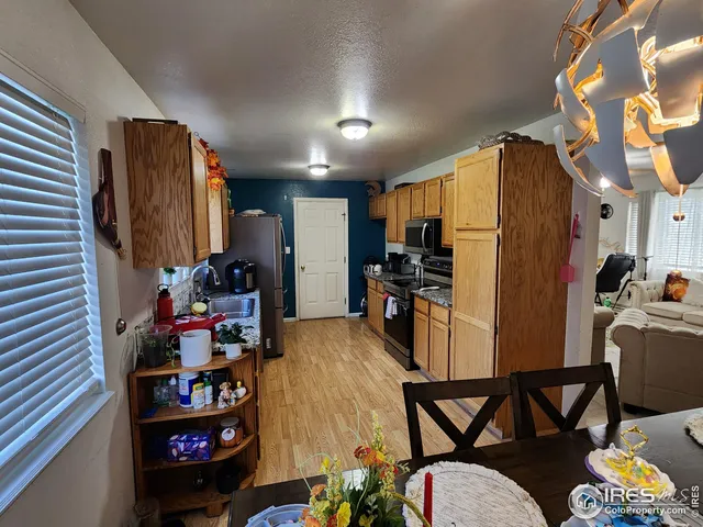 a view of a kitchen with fridge and workspace