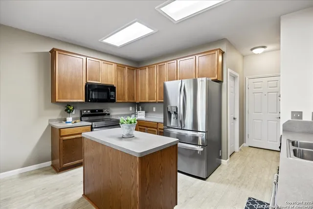 a kitchen with stainless steel appliances a refrigerator stove microwave and sink