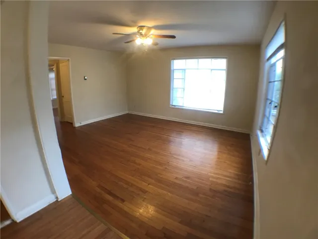 a view of empty room with window and wooden floor