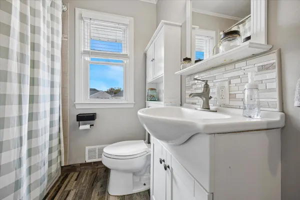 a bathroom with a sink a toilet and a mirror