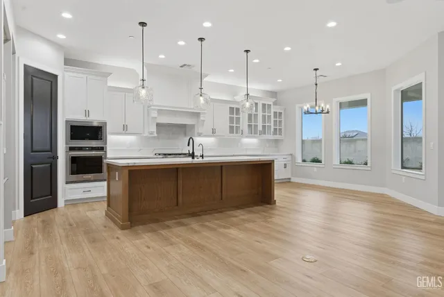 a view of empty room with wooden floor chandelier and fireplace