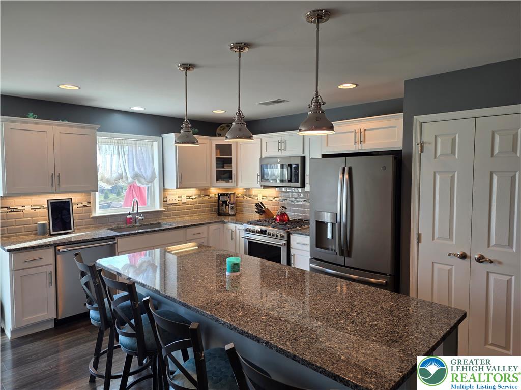3393 Crestview Lane Walnutport, PA 18088 - Photo 18 of 68 a kitchen with granite countertop a table chairs refrigerator and microwave