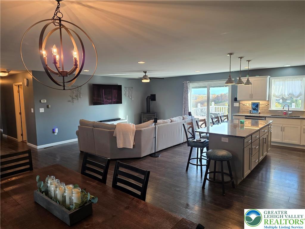 3393 Crestview Lane Walnutport, PA 18088 - Photo 37 of 68 a dining room with wooden floor a chandelier a wooden table and chairs