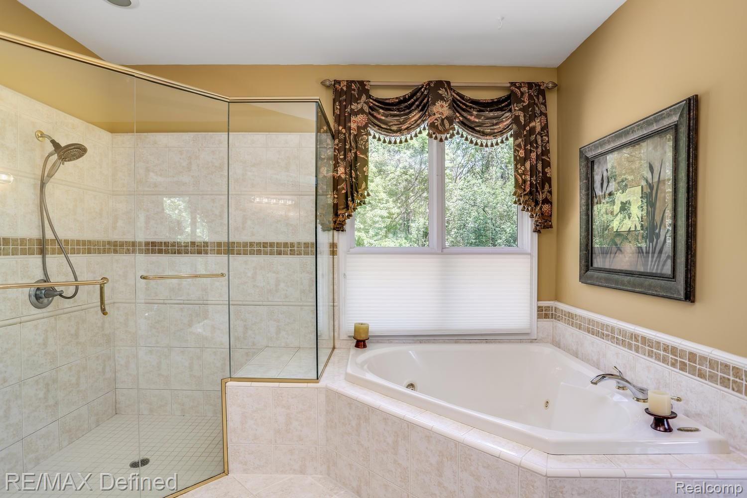 4205 Sheldon Road Rochester, MI 48306 - Photo 30 of 50 A deep jetted tub accented by a large glass door shower.