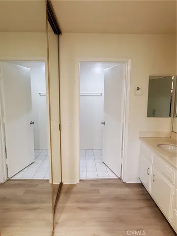 an empty room with wooden floor and mirror