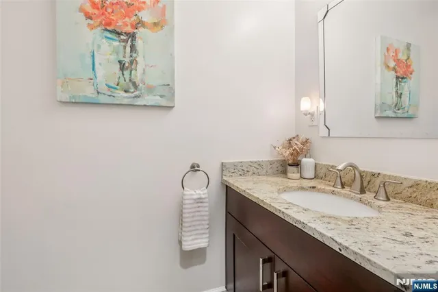a bathroom with a granite countertop sink and a mirror