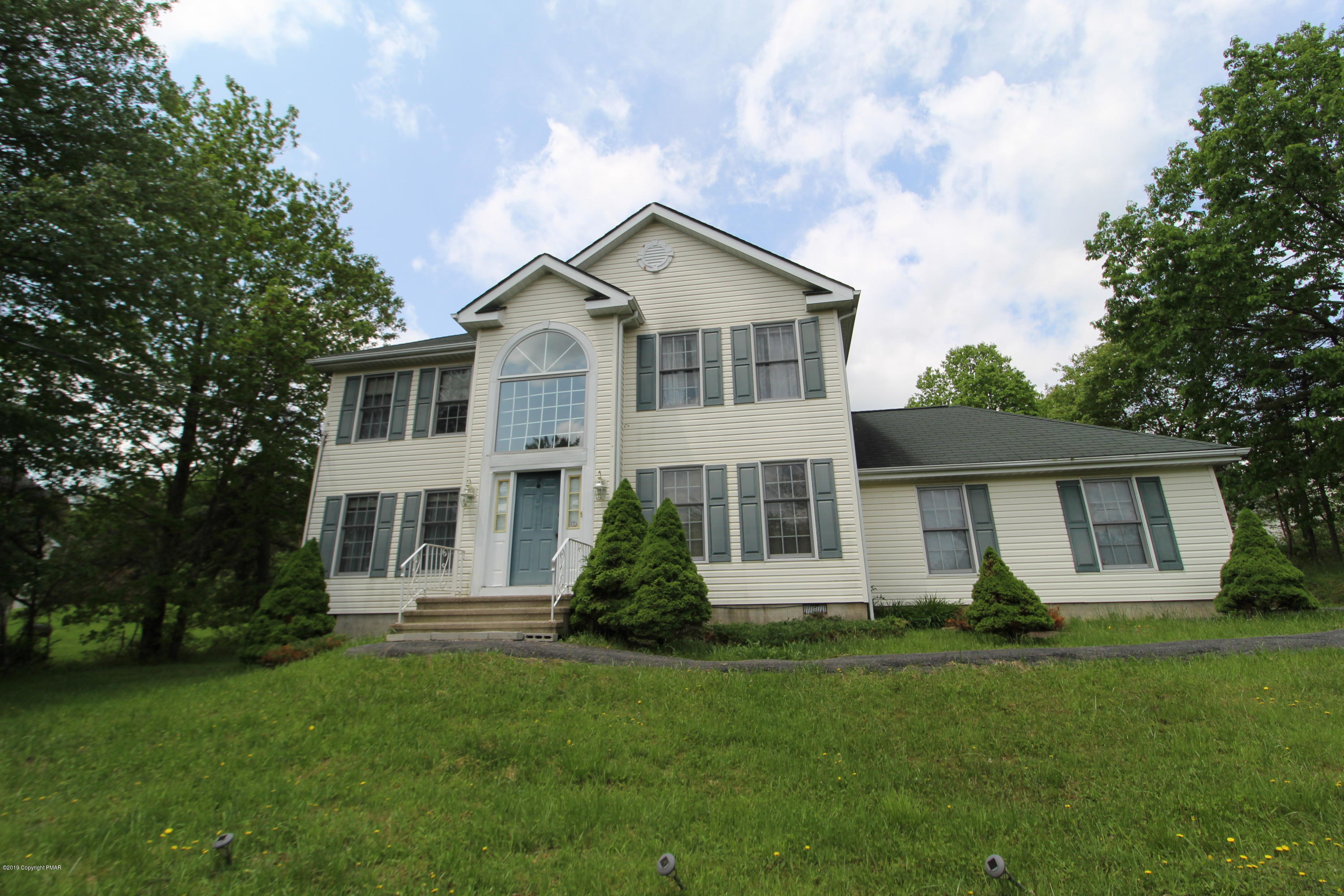 a front view of house with yard and green space