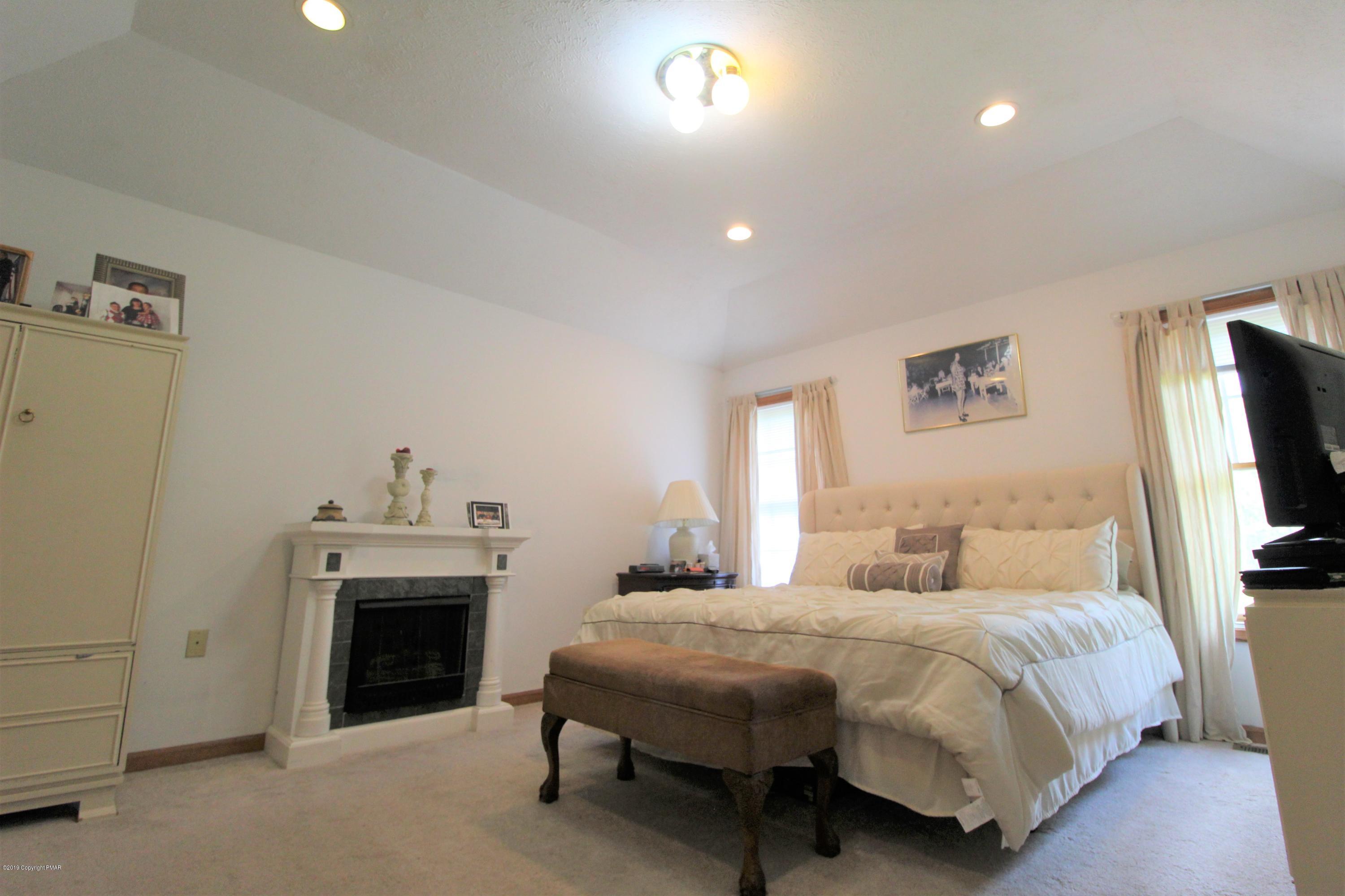 195 Granite Road Long Pond, PA 18334 - Photo 20 of 29 a spacious bedroom with a bed and a flat screen tv
