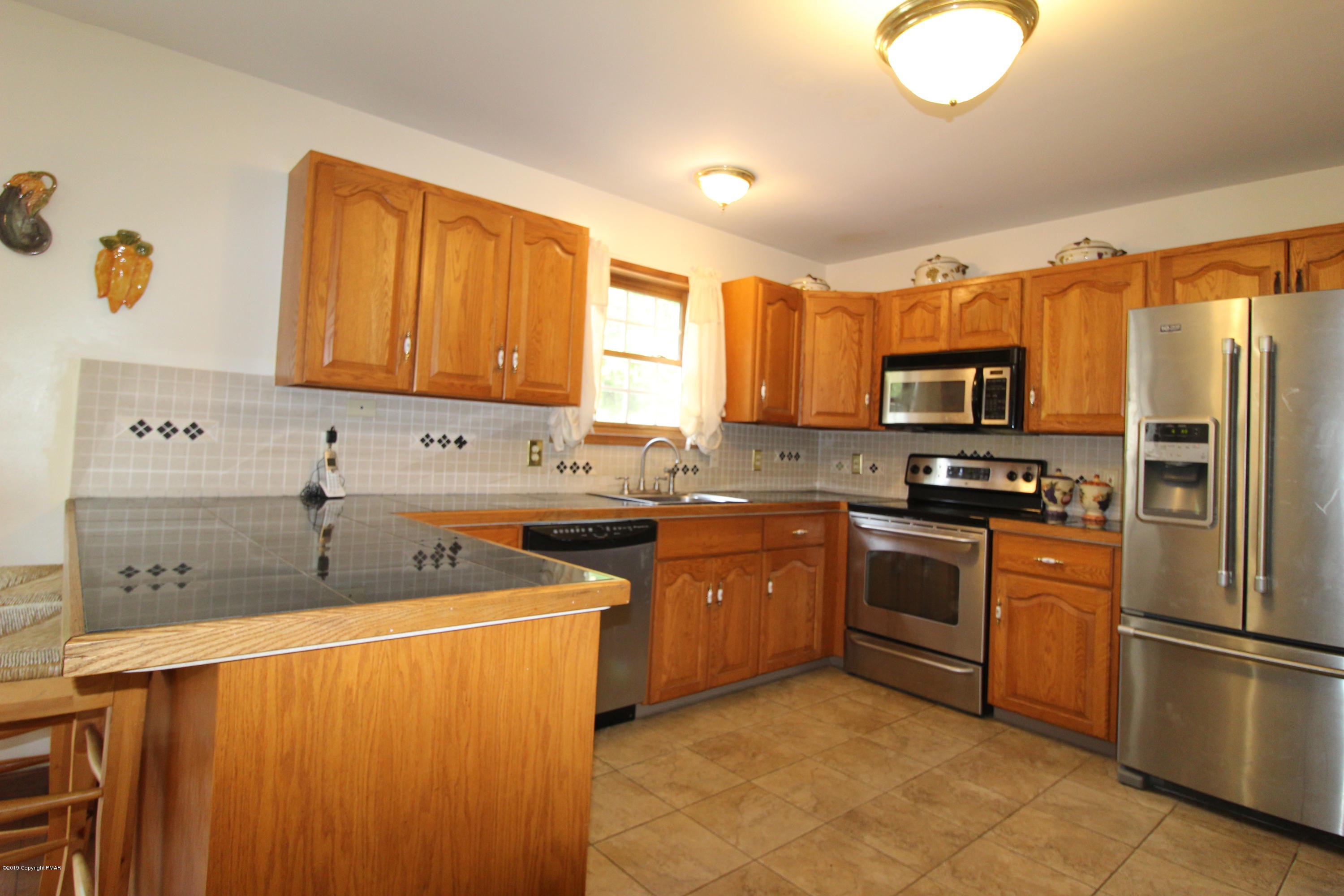 195 Granite Road Long Pond, PA 18334 - Photo 8 of 29 a kitchen with stainless steel appliances granite countertop a stove a sink dishwasher a refrigerator and a microwave oven